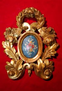 Bellissimo piccolo fregio intagliato a motivi vegetali   dorato in oro zecchino.Al centro dipinto con fiori.XVIII° sec. cm.31x25
